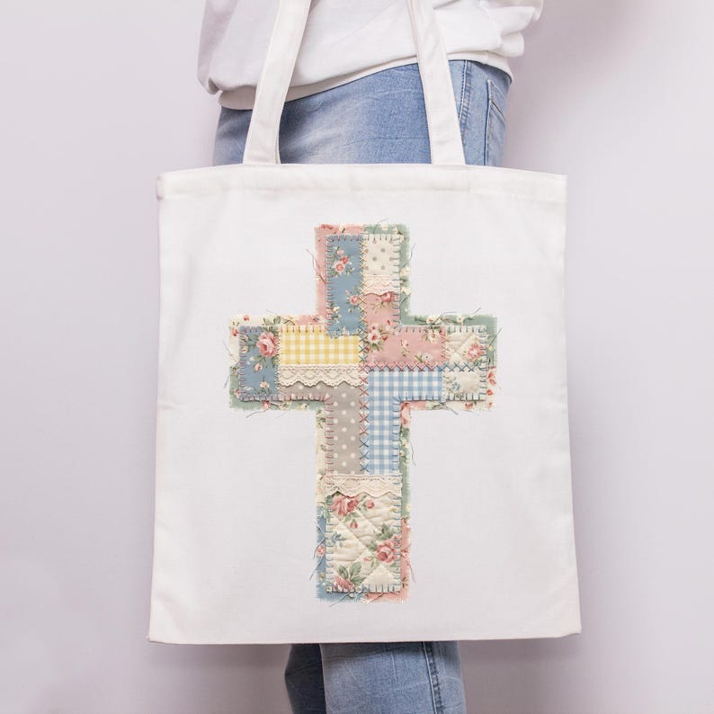 K&ouml;nnte beinhalten: Wei&szlig;e Tragetasche mit einem Patchwork-Kreuz-Design. Das Kreuz besteht aus verschiedenen floralen und gemusterten Stoffen in Pastellt&ouml;nen, darunter Rosa, Blau, Gelb und Gr&uuml;n. Die Tasche hat zwei wei&szlig;e Griffe.