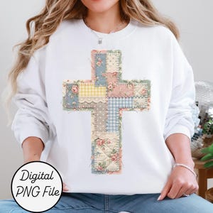 Könnte beinhalten: Weißes Sweatshirt mit einem Patchwork-Kreuz-Design. Das Kreuz besteht aus verschiedenen Stoffmustern, darunter Blumenmuster, Vichy-Karo und Spitze, in Pastellfarben. Der Text "Digital PNG File" befindet sich in einem Kreis unten.