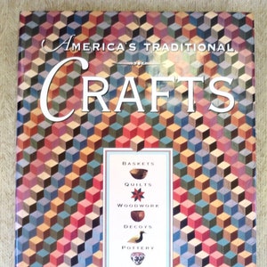 May include: A book titled "America's Traditional Crafts" with a colourful geometric pattern on the cover. The book features a list of crafts including baskets, quilts, woodwork, decoys, pottery, and more.