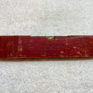 May include: A red wooden level with a yellow bubble level and the text "Level No. 169 - 12" and "Made in U.S.A."