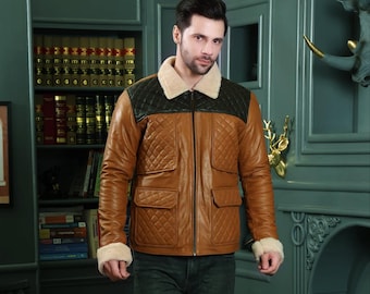 May include: A brown leather jacket with a quilted design, black shoulder panels, and a cream-colored shearling collar and cuffs. The jacket has two front pockets and a zipper closure. The model is wearing dark jeans.