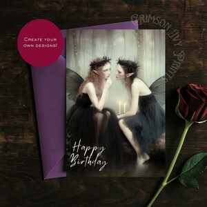 May include: A greeting card with a fantasy illustration of two fairies in black dresses and wings, with the words "Happy Birthday". A red rose and a purple envelope are also visible.