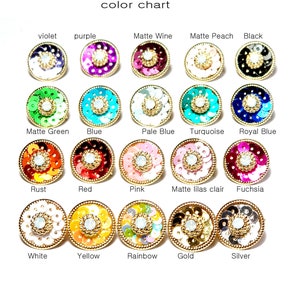 May include: Color chart showing 15 different colors of round, sequined embellishments. The embellishments are arranged in three rows of five. Each embellishment has a gold rim and a white center.