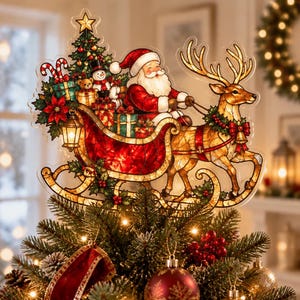May include: A stained-glass style Christmas tree topper featuring Santa Claus in a red sleigh pulled by a reindeer. The design includes a decorated pine tree, a snowman, a teddy bear, wrapped gifts, and a lantern, all rendered in vibrant colours.