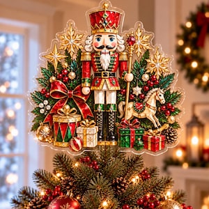 Könnte beinhalten: Ein dekorativer Weihnachtsbaumspitzen-Aufsatz mit einer zentralen Nussknacker-Figur in rot-goldener Uniform, umgeben von grünen Tannenzweigen, roten Schleifen, goldenen Sternen, Geschenkpaketen und einem kleinen Schaukelpferd auf Acrylbasis.
