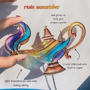 May include: A resin suncatcher shaped like a genie lamp with a multi-colored gradient finish including blue, purple, orange, and yellow hues. The design features metallic outlines, glitter accents, and text labels describing light transmission and veins.