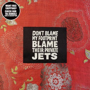 Puede incluir: Un parche rectangular negro con texto blanco que dice "DON'T BLAME MY FOOTPRINT BLAME THEIR PRIVATE JETS." Un gráfico circular en la esquina superior izquierda dice "WANT FREE SHIPPING? CHECK OUR 10X BUNDLE LINK IN DESCRIPTION."