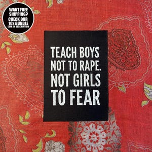 以下が含まれることがあります： 「TEACH BOYS NOT TO RAPE, NOT GIRLS TO FEAR」と書かれた白い文字が特徴の黒い長方形のサイン。赤い模様の背景に配置されています。左上隅にある円形のグラフィックには「WANT FREE SHIPPING? CHECK OUR 10X BUNDLE LINK IN DESCRIPTION」と書かれています。