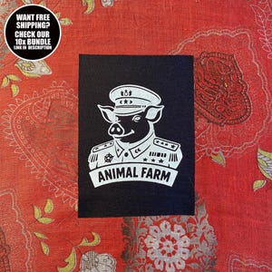 Può includere: Una toppa nera con un'illustrazione bianca di un maiale in uniforme militare, con la scritta "ANIMAL FARM" su uno stendardo. La toppa include anche il testo "WANT FREE SHIPPING? CHECK OUR 10X BUNDLE LINK IN DESCRIPTION" in un cerchio.