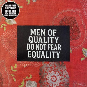 Könnte beinhalten: Ein schwarzer rechteckiger Aufnäher mit dem weißen Text "MEN OF QUALITY DO NOT FEAR EQUALITY" ist auf einem roten Stoff mit Muster zentriert. Eine kreisförmige Grafik oben links lautet "WANT FREE SHIPPING? CHECK OUR 10X BUNDLE LINK IN DESCRIPTION."