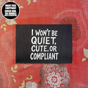 Peut inclure: Un patch rectangulaire noir avec le texte blanc "I WON'T BE QUIET, CUTE, OR COMPLIANT" est affiché sur un tissu rouge à motifs. Un graphique circulaire dans le coin supérieur gauche indique "WANT FREE SHIPPING? CHECK OUR 10x BUNDLE LINK IN DESCRIPTION."