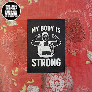 Puede incluir: Parche negro con el texto "MY BODY IS STRONG" y una ilustración de una persona flexionando sus bíceps. El parche también tiene el texto "WANT FREE SHIPPING? CHECK OUR 10X BUNDLE LINK IN DESCRIPTION" en un diseño circular.