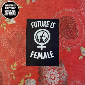 May include: A black patch with the words "FUTURE IS FEMALE" in white, along with a graphic of the Earth inside a female symbol. The patch is on a red patterned fabric. A circular graphic in the upper left corner says "WANT FREE SHIPPING? CHECK OUR 10X BUNDLE LINK IN DESCRIPTION".