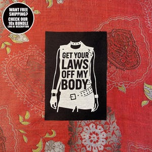 Puede incluir: Parche cuadrado negro con un gráfico blanco de una camiseta sin mangas con el texto "GET YOUR LAWS OFF MY BODY". El parche está sobre una tela roja estampada. Un gráfico circular en la esquina superior izquierda dice "WANT FREE SHIPPING? CHECK OUR 10X BUNDLE LINK IN DESCRIPTION".