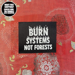 Könnte beinhalten: Ein schwarzer Aufnäher mit weißem Text "BURN SYSTEMS NOT FORESTS". Das Wort "BURN" hat flammenartige Designs über den Buchstaben. Der Aufnäher befindet sich auf einem roten Stoff mit Muster. Eine kreisförmige Grafik oben links sagt "WANT FREE SHIPPING? CHECK OUR 10X BUNDLE LINK IN DESCRIPTION."