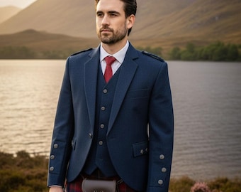May include: A navy blue three-piece suit with a red tie and a traditional Scottish kilt. The suit features a tailored jacket, vest, and matching trousers. A brown leather sporran with a stag emblem hangs from the waist. The background shows a lake and mountains.
