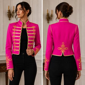 May include: A vibrant fuchsia military-style jacket featuring a high collar, long sleeves, and gold braided cord trim. The front and back are adorned with intricate gold embroidery, decorative gold buttons, and gold piping along the edges.