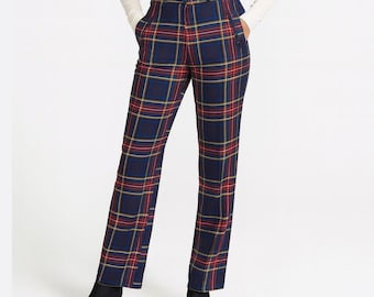 Può includere: Pantaloni blu navy a quadri con dettagli rossi e gialli. I pantaloni hanno un taglio dritto e vita alta. La modella indossa stivaletti neri. Uno stile classico.