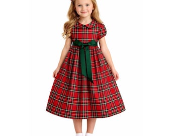 Op de afbeelding: Een rode geruite jurk met een groene sjerp en een Peter Pan kraag. De jurk heeft korte mouwen en een volle rok. Het meisje draagt rode schoenen en een rode strik in haar haar. Geschikt voor een feestelijke gelegenheid.
