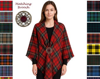 May include: A red and green plaid shawl with a matching brooch. The shawl is draped over a person and is fringed at the edges. The text "Available in 50 Custom Tartans" is at the top.