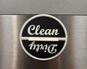 May include: A circular dishwasher magnet with a black background and a white border. The magnet features a horizontal white divider and white text that reads Clean on the top half and Dirty on the bottom half, with the word Dirty oriented upside down.