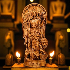 May include: A detailed wooden statue of Inanna, an ancient Mesopotamian goddess, with wings, an owl, and a lion. The statue is illuminated by candlelight, creating a warm, inviting atmosphere. The word "INANNA" is carved at the base.