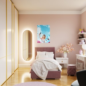May include: A bedroom decorated in pink and white tones. A bed with a mauve headboard and white bedding is the focal point. Above the bed is a framed artwork of a person taking a selfie. A large mirror and a white wardrobe are on the left.