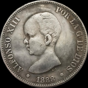 May include: Silver coin featuring a profile portrait of King Alfonso XIII of Spain. The coin is dated 1888 and reads "ALFONSO XIII" and "POR LA G. DE DIOS" around the edge.