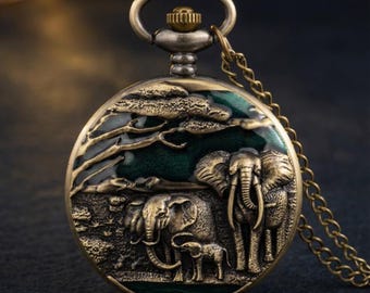 Reloj de bolsillo vintage en tono bronce con intrincado relieve de familia de elefantes y detalles de esmalte verde, completo con cadena.