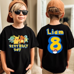 May include: Black t-shirt with a colorful graphic of cartoon characters and the text "BIRTHDAY BOY". The back of the shirt displays the name "Liam" and the number "8" in blue and yellow, with a Poké Ball graphic.