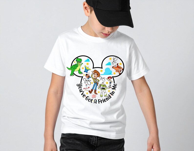 May include: White t-shirt featuring a black Mickey Mouse head design with Toy Story characters. The shirt includes the text "You've Got a Friend in Me" in a circular font. The design showcases characters like Woody, Buzz Lightyear, and Rex.