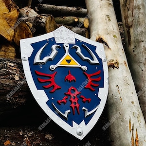 May include: A blue, white, and red shield with a silver trim and rivets. The shield features a central yellow triangle and red emblem. The shield is leaning against a pile of logs and tree trunks.