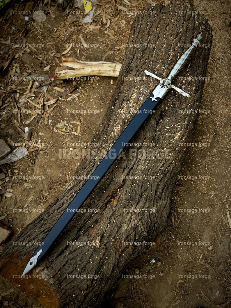 K&ouml;nnte beinhalten: Ein langes, silbernes und schwarzes Schwert mit kreuzf&ouml;rmigem Griff liegt auf einem verwitterten Holzstamm. Die Klinge ist schwarz, und der Griff und der Knauf sind silberfarben. Das Schwert wird im Freien ausgestellt.