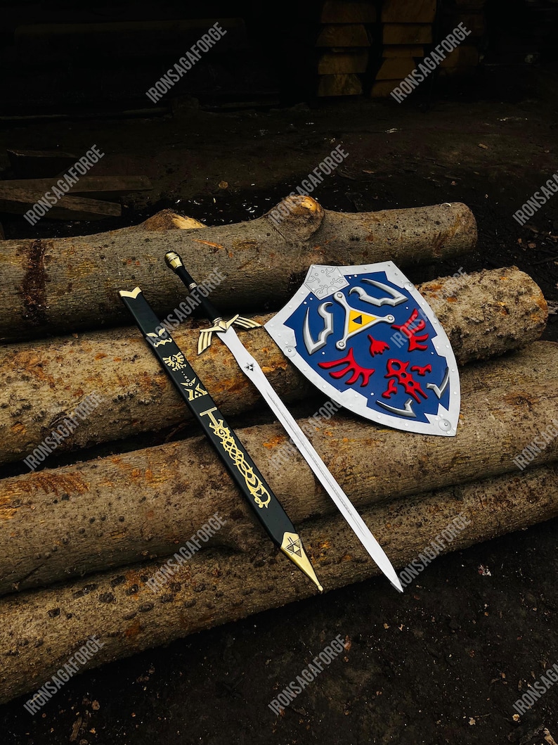 May include: A sword, scabbard, and shield set. The sword has a silver blade and black handle. The scabbard is black with gold accents. The shield is blue with red and yellow details. The text "IRONSAGAFORGE" is visible.