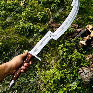 May include: A curved, silver-colored sword with a wooden handle. The blade has a decorative pattern along the spine and a star design near the hilt. The handle is dark brown with silver accents.