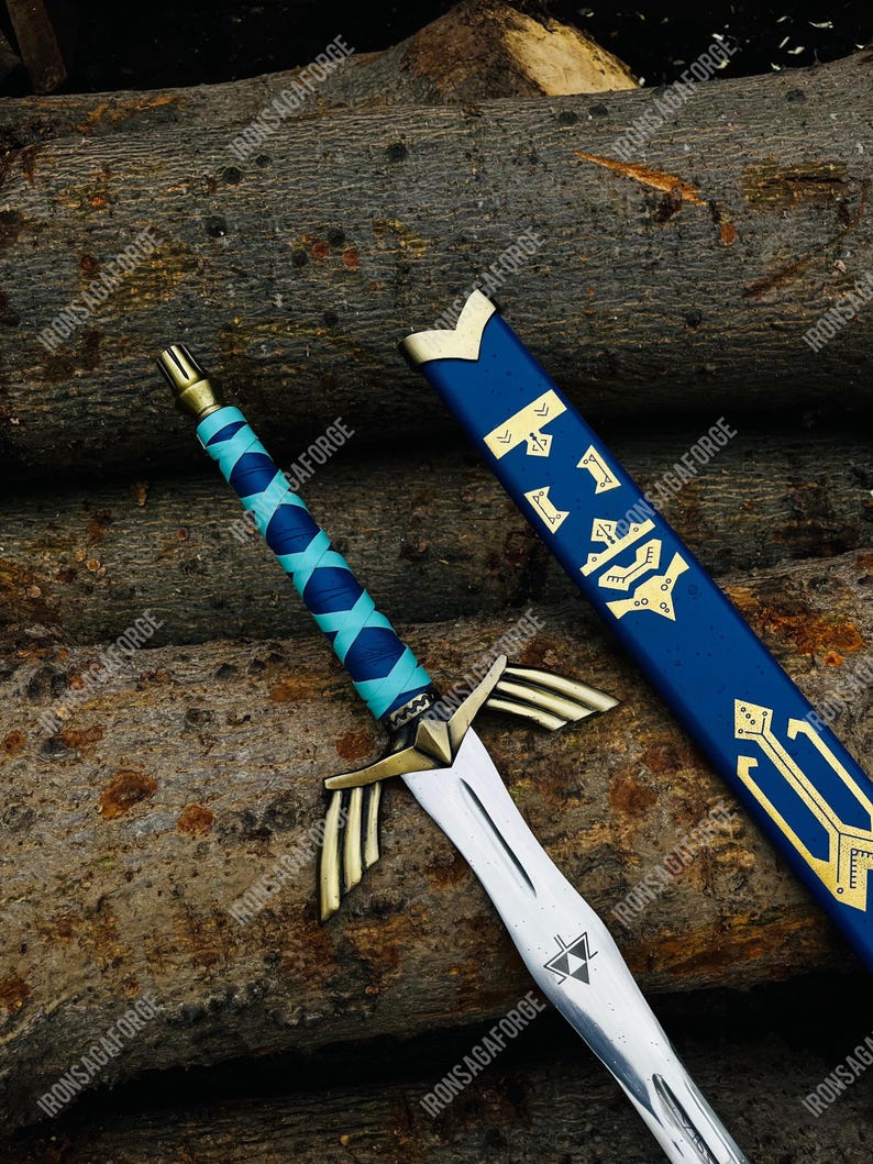 May include: A detailed image of a fantasy sword with a silver blade and gold accents. The hilt is wrapped in blue and turquoise leather. The blue scabbard has gold symbols. The sword is displayed on a background of wooden logs. The text "IRONSAGAFORGE" is visible.