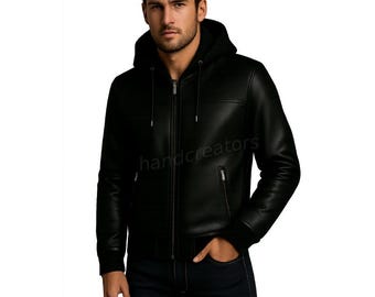 May include: Black leather jacket with a hood and a zipper closure. The jacket has two front pockets and the text "handcreators" printed on the front. The model is wearing dark blue jeans.