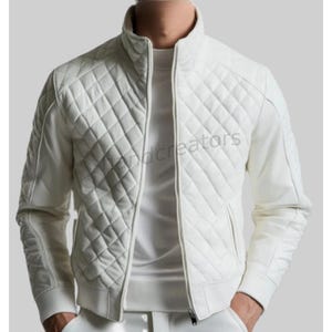 Könnte beinhalten: Eine weiße Steppjacke mit Stehkragen und Reißverschluss. Die Jacke hat ein Rautenmuster auf der Vorderseite und den Ärmeln, mit geripptem Saum und Bündchen. Die Jacke hat zwei Seitentaschen und ist aus einem glatten, möglicherweise lederartigen Material.