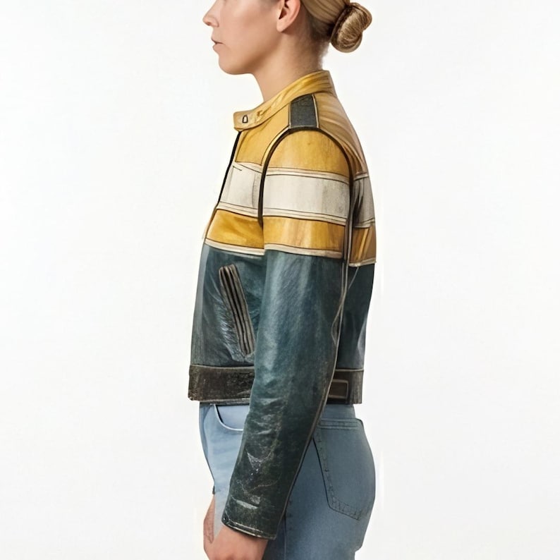 Op de afbeelding: Een kort leren jack met een color-block ontwerp, bestaande uit een mosterdgeel bovendeel, een horizontale witte streep en een donkergroenblauw onderstuk. Het jack is voorzien van een opstaande kraag en lange mouwen.