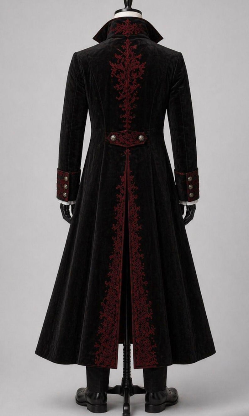 May include: A long black coat with red embroidered accents. The coat features a high collar, decorative buttons, and ornate embroidery down the back and along the front edges. The sleeves have red cuffs with three buttons. The coat is displayed on a mannequin.