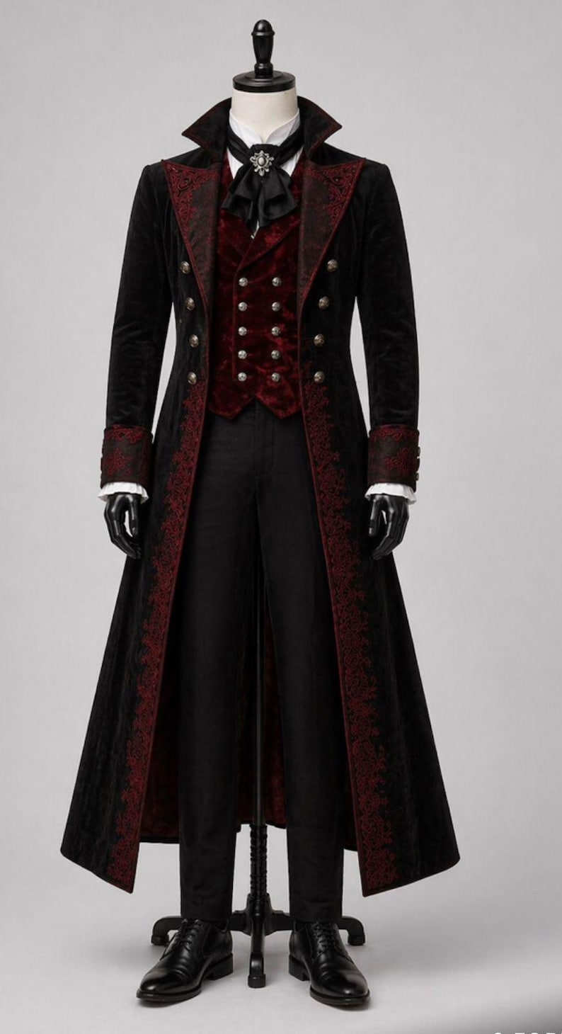 May include: A black velvet coat with red embroidered trim, paired with a red vest and black trousers. The coat features ornate buttons and cuffs, and is displayed on a mannequin. The outfit is completed with a black tie and shoes.