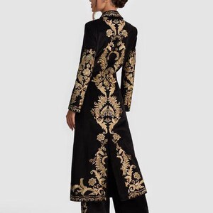 May include: Black velvet coat and matching pants set with gold floral embroidery. The long coat features a high collar and a split back. The gold embroidery is on the sleeves, back, and pant legs. The outfit is elegant and suitable for special occasions.
