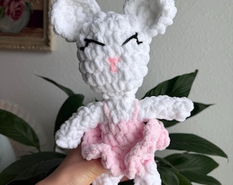 Könnte beinhalten: Ein weißes, gehäkeltes Plüschmaus-Spielzeug mit weicher, strukturierter Garnoberfläche. Die Maus trägt ein hellrosa gehäkeltes Tutu und passende rosa Ballettschuhe. Sie hat gestickte schwarze Augen und eine kleine rosa Nase.