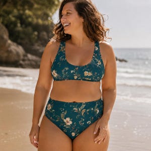 May include: A two-piece swimsuit featuring a dark teal base color with a repeating floral pattern in shades of cream, light brown, and muted green. The top has a scoop neckline and wide straps, while the bottoms are a high-waisted bikini style.