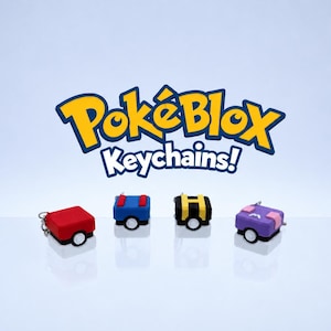 Puede incluir: Cuatro llaveros PokèBlox coloridos en rojo, azul, negro y morado. Cada llavero tiene un diseño único con ruedas blancas y un llavero plateado. El logotipo "PokèBlox Keychains!" se muestra arriba.