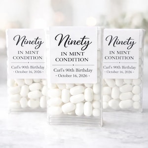 May include: Three clear plastic containers filled with white mints. Each container has a white label with the words "Ninety IN MINT CONDITION" and "Carl's 90th Birthday - October 16, 2026."