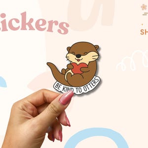 Adesivo "Sii gentile con le lontre" - Simpatico gioco di parole in vinile con animali - Olografico, opaco o lucido - Regalo di amore per se stessi e gentilezza - Spedizione gratuita in Canada