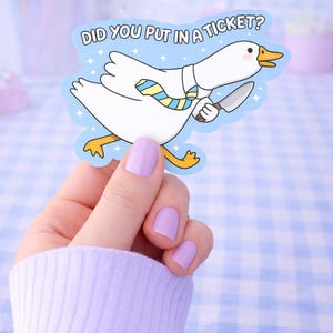 May include: A sticker depicting a cartoon goose holding a knife, with the text "DID YOU PUT IN A TICKET?". The goose is white with yellow feet and a beak, wearing a tie. The background is blue with star accents.