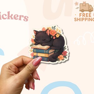 Sticker Chat endormi sur des livres - Vinyle floral confortable pour les amoureux des livres - Esthétique de lecture de joli chat noir pour un journal ou un ordinateur portable
