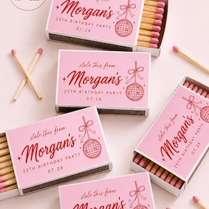 May include: Several matchboxes with pink labels featuring red text that reads "stole this from Morgan's 25TH BIRTHDAY PARTY 07.26" and a disco ball graphic. The labels measure 3.81 cm by 5.72 cm. The matches inside have pink tips.